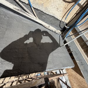 צל של אדם על משטח איטום עם צינורות