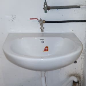 כיור עם ברזים וצינורות חשופים