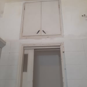 ארון מעל דלת בחדר עם קירות צבועים