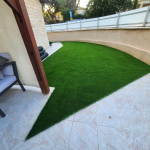 דשא סינתטי מותקן בחצר עם ריצוף קרמיקה
