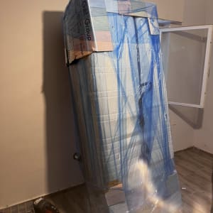 מקרר עטוף בניילון כחול בחדר ריק