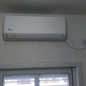 מזגן מותקן על קיר עם כבל חשמל מחובר