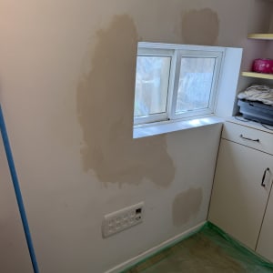 קיר עם תיקוני צבע ליד חלון קטן