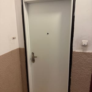דלת לבנה עם ידית מתכת במסדרון
