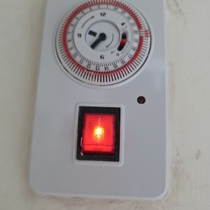 טיימר עם מתג אדום על קיר לבן