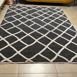 שטיח שחור לבן על רצפה ליד ספה צהובה