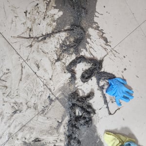 לכלוך ובוץ על הרצפה עם כפפה כחולה