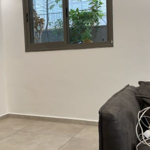 קיר לבן עם חלון, ספה וכבלים