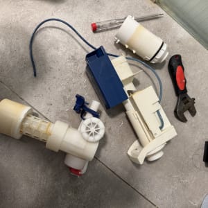 חלקי אינסטלציה וכלים על רצפה אפורה