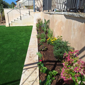 ערוגת פרחים עם צמחים ופרחים צבעוניים בגינה