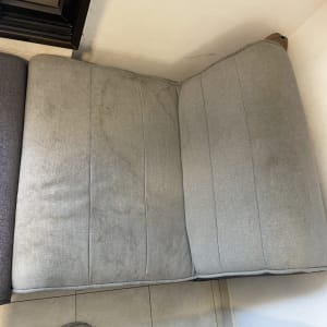 כרית ספה אפורה עם כתמים על הריפוד