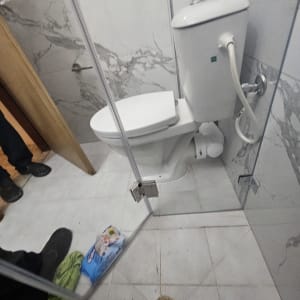 אסלה ומקלחון בחדר אמבטיה עם ניקוז ברצפה