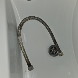 צינור מתכת ישן באמבטיה עם ניקוז