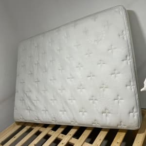 מזרן לבן עומד על מסגרת עץ