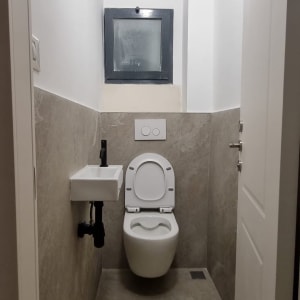 שירותים עם כיור קטן וקיר לבן