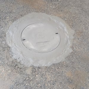 מכסה ביוב עגול עם בטון רטוב מסביב