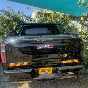 רכב GMC שחור חונה תחת סככה ירוקה