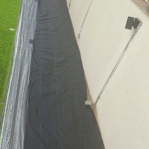 בד שחור פרוס על הקרקע ליד דשא סינתטי