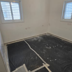 חדר עם יריעות פלסטיק על הרצפה לקראת צביעה