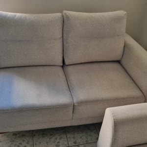 ספה אפורה עם דלי ירוק על רצפה