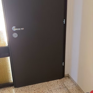 דלת חומה עם ידית מתכת על רצפת אריחים