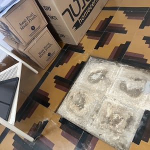רצפה עם אריחים חשופים וקרטונים בפינה