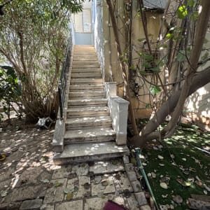 מטאטא אדום על רצפה ליד מדרגות חיצוניות