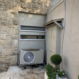 יחידת מיזוג אוויר ליד קיר אבן