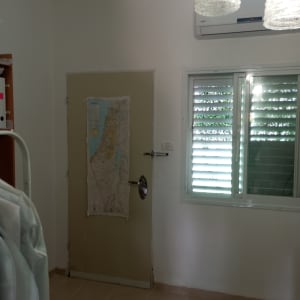 חדר עם דלת, חלון ומפה על הקיר