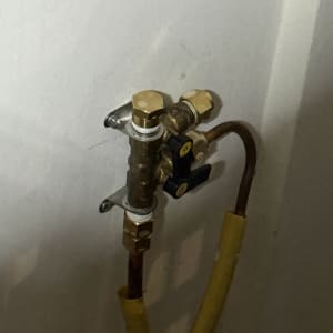 שסתום גז עם צינור צהוב מחובר לקיר