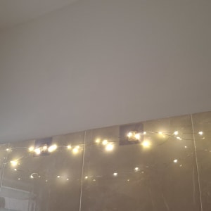 אורות קטנים תלויים על קיר עם אריחים