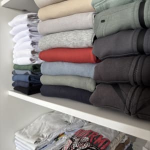 בגדים מקופלים ומסודרים על מדפים בארון
