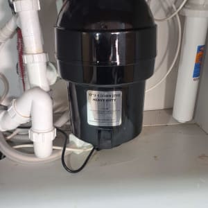 טוחן אשפה מתחת לכיור עם צינורות חיבור