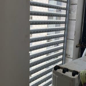 רשת מתכת מותקנת על חלון למניעת כניסת יונים