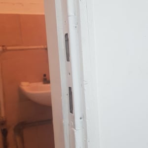 דלת לבנה עם משקוף ומנעול ללא ידית