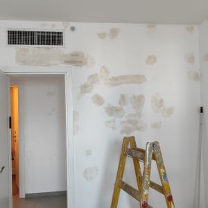 קיר עם תיקוני טיח וסולם צהוב