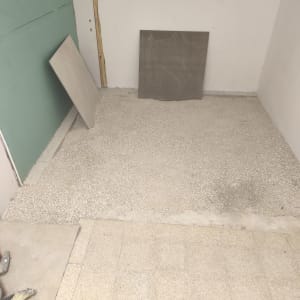 חדר עם רצפה בתהליך ריצוף ואריחים מונחים