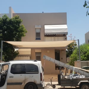 שני סוככים מותקנים על חזית בית פרטי