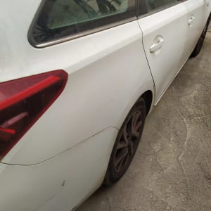 מכונית לבנה חונה על כביש בטון