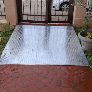 שער מתכת עם ריצוף מתכת מבריק בכניסה