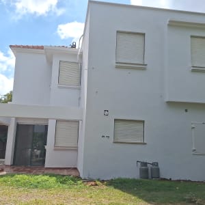 קיר חיצוני של בית עם חלונות סגורים ובלוני גז