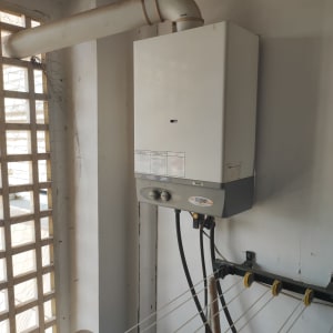 דוד חימום מותקן על קיר עם צינורות חיבור