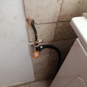 צינור גז מחובר לקיר ליד מכונת כביסה
