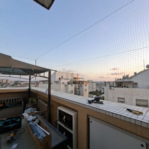 רשת יונים מותקנת על מרפסת עם כלים ועבודת התקנה