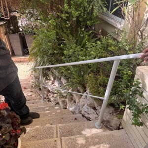 מעקה מתכת ליד מדרגות וגינה