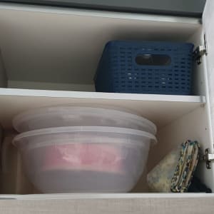 ארון פתוח עם קופסאות פלסטיק וסלסלה כחולה