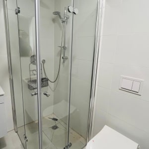 מקלחון זכוכית עם ראש מקלחת וכיור קטן