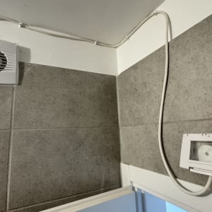 מאוורר קיר חשמלי וחוטי חשמל על קיר