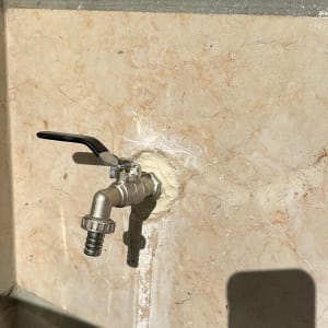 ברז מתכת מותקן על קיר אבן