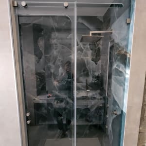 מקלחון זכוכית עם עיצוב מודרני וראש מקלחת